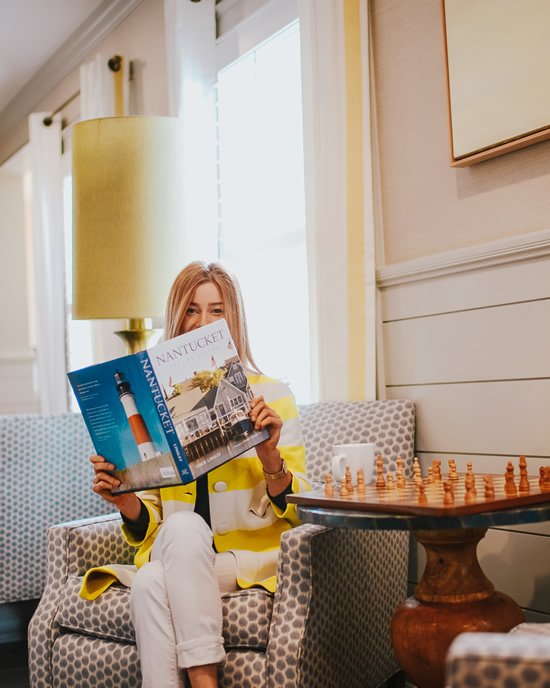 Woman Guest Sitting & Reading a Nantucket Book in The Nantucket Hotel's Lobby